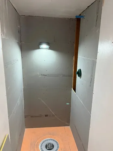 Shower enclosure boarded in cement backer board over the new pan