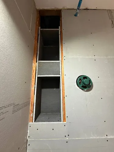 Two recessed shower niches framed and boarded into the wall