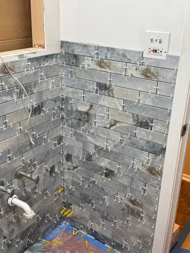 Grey marble wainscot running around the room above the floor tile