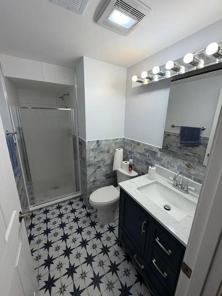 Finished bathroom remodel in Schaumburg, IL — new vanity, glass shower door and patterned tile floor