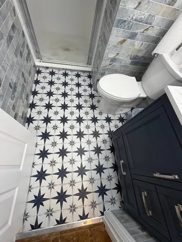 Patterned floor tile, marble wainscot and new navy vanity after completion