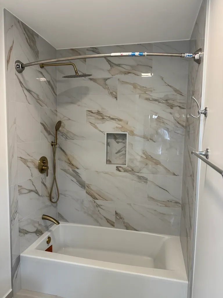 Marble-look shower with brushed brass fixtures