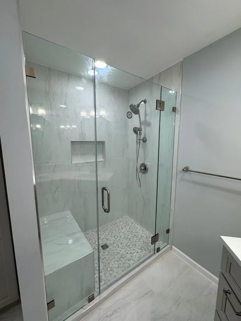 Glass-enclosed shower with tiled bench and niche