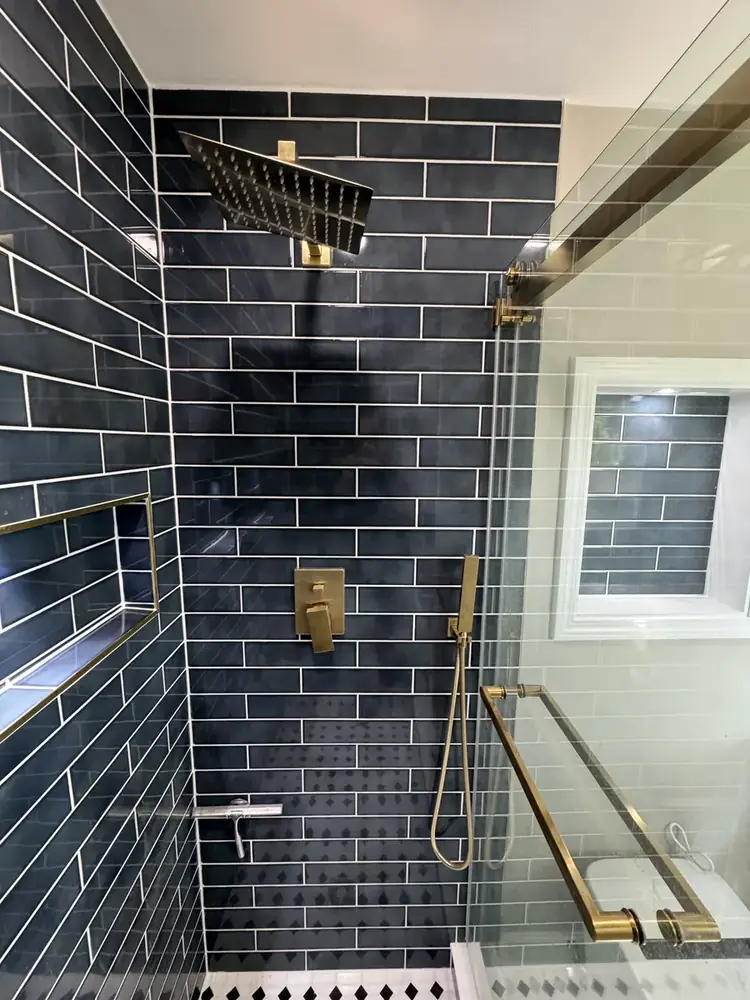 Finished shower with glass door and brass hardware